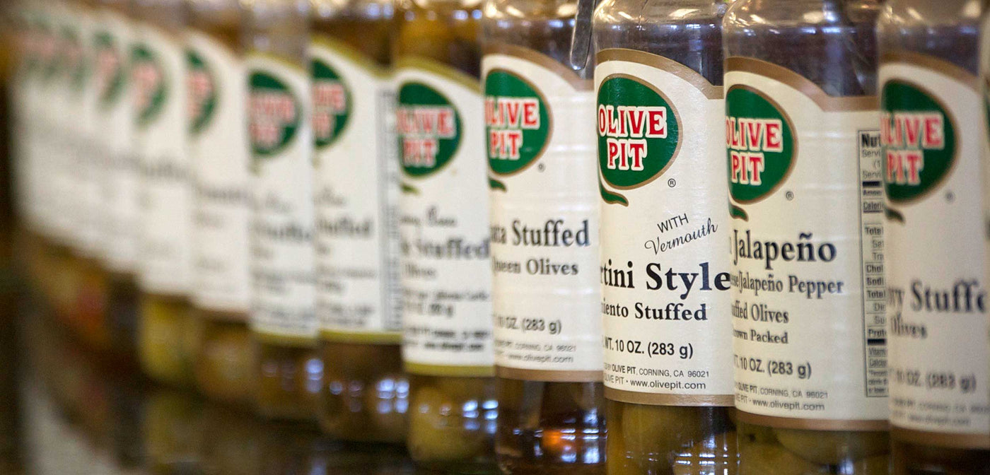 Many jars of Olive Pit Olives, close-up. 